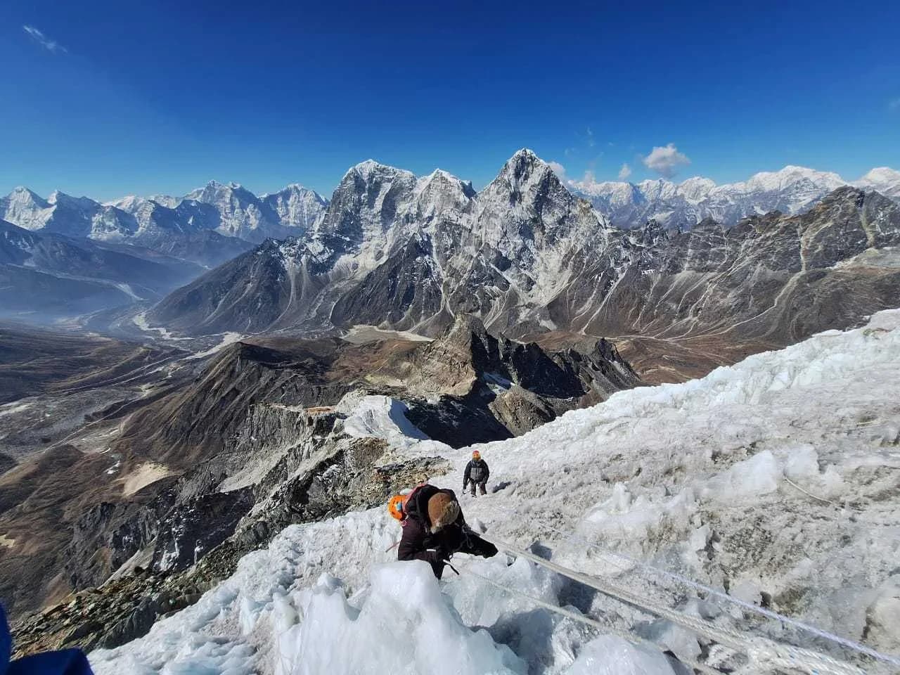 Peak climbing in Nepal,Trekker-climbing-Lobuche-Peak-with-rope-support-against-a-backdrop-of-snowy-mountain-terrain